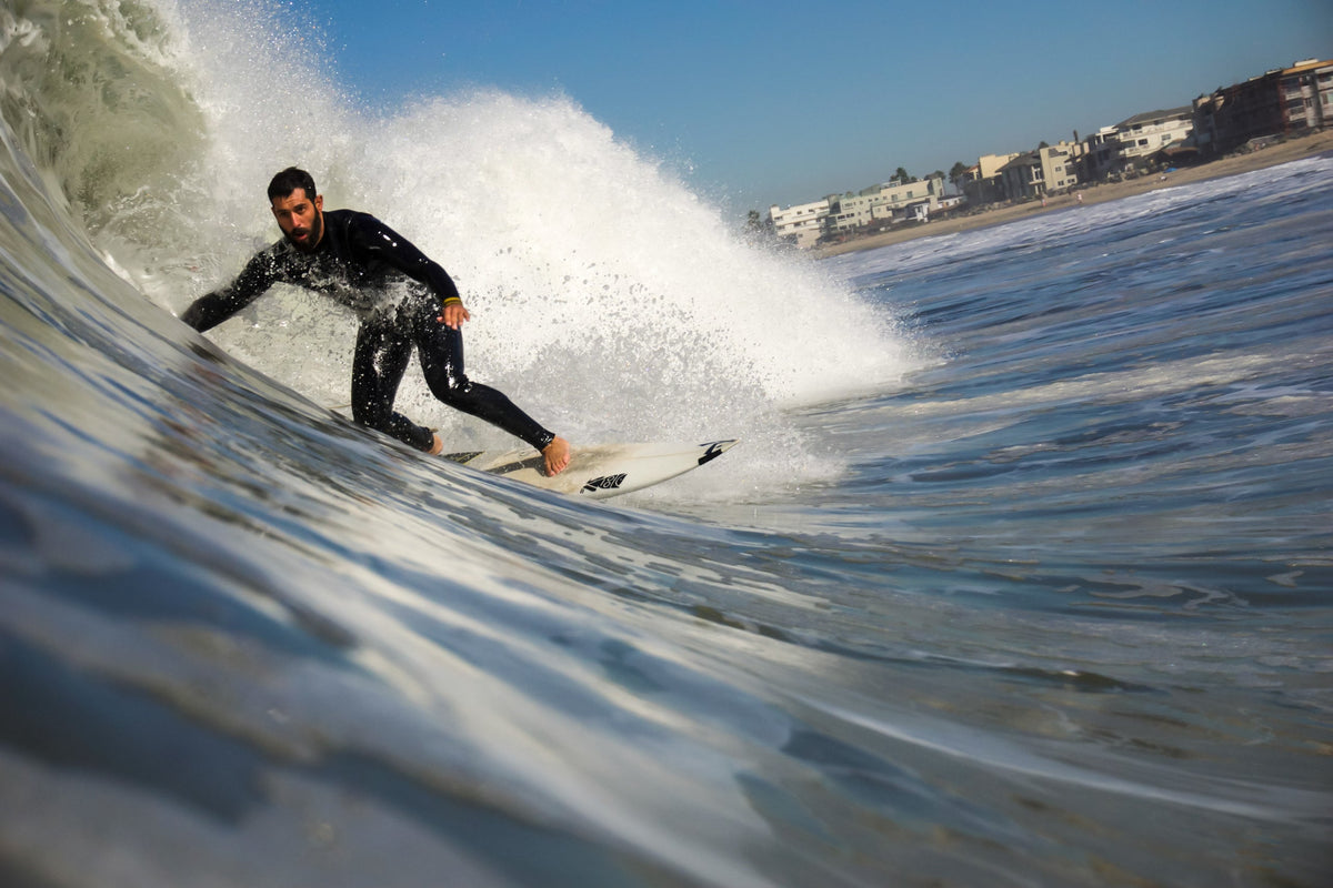 Surfer gets barreled at IB in a dirty frothy wave. 