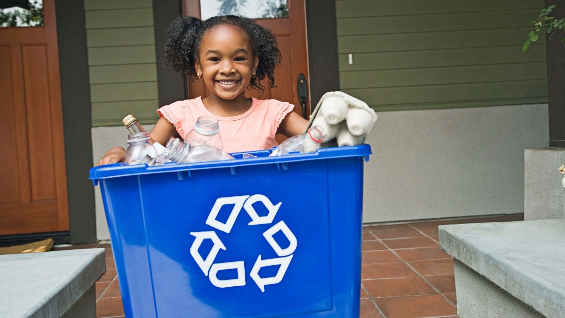 Little girl smiling and recycling 